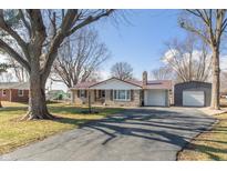 Charming single-story home features a stone facade, red metal roof, and mature trees in the front yard at 1780 S Mauxferry Rd, Franklin, IN 46131