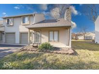 Charming condo with attached garage and front yard is surrounded by green grass and mature trees at 2552 Spring Hill Ct, Indianapolis, IN 46268