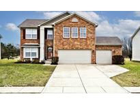 Inviting two-story brick home features a well-maintained lawn and attached two-car garage at 2879 Bluewood Way, Plainfield, IN 46168
