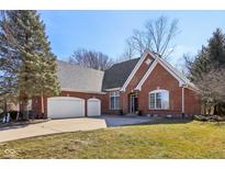 Traditional brick home with a three car garage, mature trees, and a well-manicured lawn at 351 Mallard Ct, Carmel, IN 46032