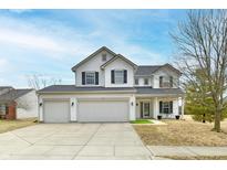 Charming two-story home features a three-car garage, and well manicured front yard at 3873 Crest Point Dr, Noblesville, IN 46062