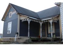 Charming home with a covered porch featuring decorative columns and gray siding at 416 Ketcham St, Indianapolis, IN 46222