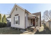 Charming home featuring a covered front porch with chairs, quaint architectural details, and well-maintained yard at 555 E Adams St, Franklin, IN 46131