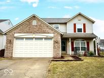 Charming two-story home featuring a brick facade and attached two-car garage with well manicured landscaping at 6830 Viola Ct, Indianapolis, IN 46237
