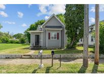 Charming gray home featuring a classic design, a well-maintained lawn, and inviting curb appeal at 818 S Grant St, Muncie, IN 47302