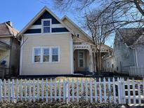 Charming two-story home featuring blue and beige exterior paint, white trim, and a lovely covered front porch at 1153 Villa Ave, Indianapolis, IN 46203