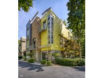 Unique contemporary home with yellow stucco, stone accents, metal balconies and lots of light at 2417 E 80Th E St, Indianapolis, IN 46240
