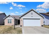 Charming single-story home featuring a brick and vinyl exterior, attached two-car garage, and well-maintained front yard at 4722 Common View Cir, Indianapolis, IN 46220
