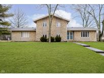 Charming stone two-story home with a well-manicured lawn at 647 Mulford Ct, Indianapolis, IN 46234