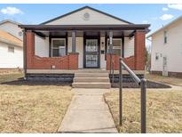 Charming home with a covered front porch, brick pillars, and a well-maintained yard at 705 N Bradley Ave, Indianapolis, IN 46201