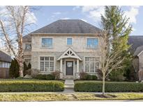 Charming two-story brick home with well-manicured landscaping and covered entrance at 7665 Carriage House Way, Zionsville, IN 46077