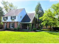 Charming two-story home featuring a brick facade, covered porch, landscaped yard, and lush green lawn at 83 W Garfield Ave, Martinsville, IN 46151