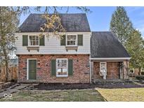 Charming brick home with green shutters, a quaint entrance, and lush landscaping at 83 W Garfield Ave, Martinsville, IN 46151