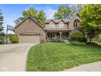 Charming home with brick and siding, inviting front porch, mature trees, and a well-manicured lawn at 9126 Pinecreek Ct, Indianapolis, IN 46256