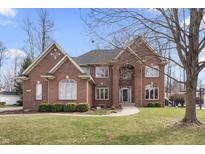 Charming two-story brick home featuring a manicured lawn and elegant architectural details at 9914 Springstone Rd, Fishers, IN 46055