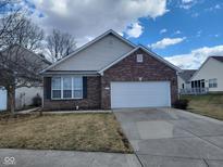 Charming single-story brick home featuring an attached two-car garage and manicured front lawn at 1017 Lincoln Park E Dr, Greenwood, IN 46142