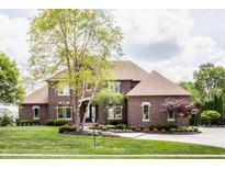 Charming two-story brick home with a meticulously landscaped front yard and well manicured lawn at 10541 Titan Run, Carmel, IN 46032