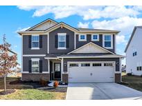 Charming two-story home with a gray exterior, complemented by a well-manicured lawn and a spacious two-car garage at 11732 Winnower, Noblesville, IN 46060