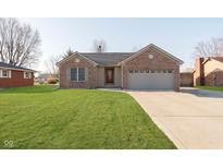 Charming brick home with well-manicured lawn and a two-car garage at 1325 E 47Th St, Anderson, IN 46013