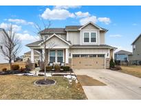 Charming two-story home features a well-maintained lawn, a two-car garage, and classic architectural details at 13553 Eastpark E Cir, Fishers, IN 46037