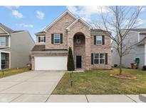 Charming two-story brick home featuring attached two car garage and well-maintained landscaping at 2091 Creek Bank Dr, Columbus, IN 47201