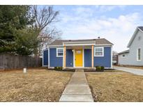 Charming blue home featuring a bright yellow front door and a well-manicured lawn at 217 E Michigan St, Fortville, IN 46040