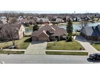 Charming brick home featuring an attached two-car garage and a well-manicured lawn with lake views at 2267 Surface Dr, Greenwood, IN 46143