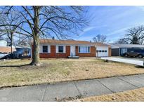 Charming brick ranch home featuring white trim, an attached garage and a well manicured front yard at 2521 Beechcrest Dr, Indianapolis, IN 46203