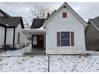 Quaint single-Gathering home with a snow-covered yard and classic architectural details at 317 S Harris Ave, Indianapolis, IN 46222