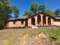 Charming brick home featuring arched entryway and freshly landscaped front yard at 8940 Black Hawk Ln, Indianapolis, IN 46234