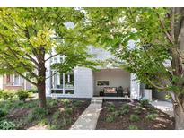 Modern townhome with a manicured front yard, featuring a gray brick facade and inviting covered porch at 932 N Broadway St # 1, Indianapolis, IN 46202