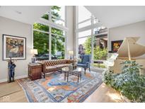 Bright living room featuring large windows, a tufted leather couch, decorative rug, and grand piano at 932 N Broadway St # 1, Indianapolis, IN 46202