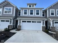 Charming townhouse showcasing a two-car garage and appealing gray siding under a clear blue sky at 1274 Newton St, Avon, IN 46123