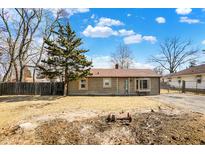 Charming single-story home with wood siding and a well-maintained front yard under a blue sky at 1529 Bailey Dr, Indianapolis, IN 46241