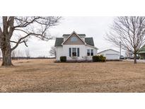 Charming two-story home with green roof and a detached garage, surrounded by an open yard at 3615 E State Rd 32, Lebanon, IN 46052