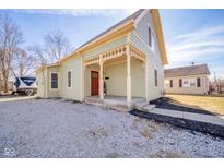 Charming single-story home features a red front door, covered porch, gravel landscaping and light green siding at 436 E Staat St, Fortville, IN 46040