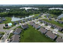 An aerial view of a community with a pool, lake, and beautifully landscaped yards at 50 Hovden Dr, Cicero, IN 46034