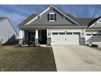 Charming home featuring a two car garage, stone accents, and a well-manicured lawn at 50 Hovden Dr, Cicero, IN 46034