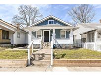 Charming blue home featuring a covered porch, landscaped yard, and inviting curb appeal at 520 N Parker Ave, Indianapolis, IN 46201