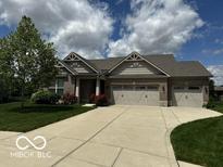 Charming brick home featuring an attached three-car garage, well-manicured lawn, and beautiful landscaping at 6117 Arctic Cir, Indianapolis, IN 46237