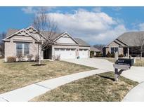 Beautiful brick home featuring a two car garage, a manicured lawn and mature landscaping at 6117 Arctic Cir, Indianapolis, IN 46237