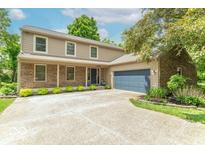 Charming two-story home featuring a brick facade, manicured lawn, and an attached two-car garage at 6530 Grant Wood Ct, Indianapolis, IN 46256