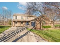 Charming two-story home with a brick facade, blue door, and attached two-car garage at 6530 Grant Wood Ct, Indianapolis, IN 46256
