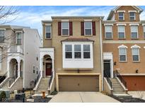 Charming brick townhome featuring a two-car garage, inviting entryway with steps, and eye-catching window shutters at 700 Greenford N Trl, Carmel, IN 46032