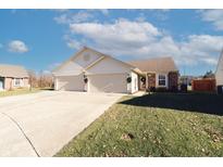 Charming single-Gathering home featuring a 2-car garage, landscaped yard, and inviting curb appeal on a sunny day at 7221 Broyles Ln, Indianapolis, IN 46217