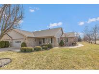 Charming brick home featuring an attached garage, well-maintained lawn, and inviting curb appeal at 7609 Silver Moon Way, Indianapolis, IN 46259