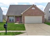 Charming single-Gathering home featuring a brick facade, attached two-car garage, and well-maintained lawn at 7751 Sergi Canyon Dr, Indianapolis, IN 46217