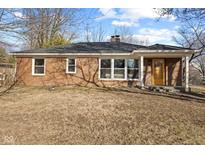 Charming brick home featuring a well-maintained lawn and inviting entrance with a bright yellow front door at 8401 N College Ave, Indianapolis, IN 46240