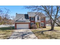 Charming two-story brick home with an attached garage, landscaped front yard, and mature trees on a sunny day at 8452 Sunningdale Blvd, Indianapolis, IN 46234