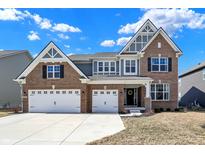Charming two-story brick home featuring a three-car garage and a welcoming front porch at 10412 Hamburg Dr, Fortville, IN 46040